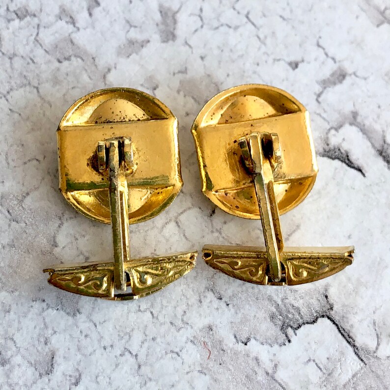 Damascene gold tone cuff links.