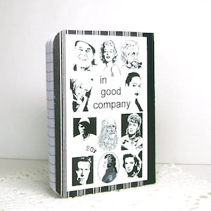 May include: Black and white notebook cover with the text "in good company" and images of famous people.