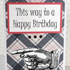 May include: A white card with a red border and black and white plaid background. The card has the text "This way to a Happy Birthday" and a black and white illustration of a pointing hand.