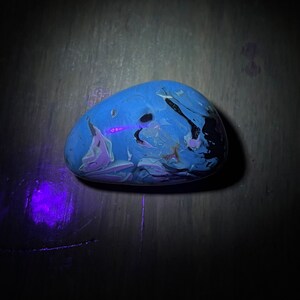 May include: A blue, white, and black marbled stone with a smooth, rounded surface.