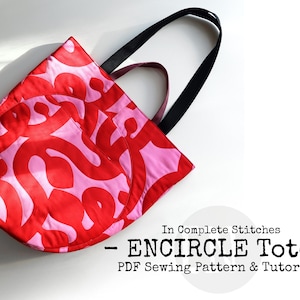 Peut inclure: Un sac cabas rose et rouge avec un motif géométrique. Le sac a des anses noires et le texte "ENCIRCLE Tote - PDF Sewing Pattern & Tutorial" est imprimé sous le sac.