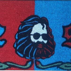 May include: A red and blue doormat with the numbers 42 and 95 on either side of a cartoon image of a man with long hair and a beard wearing sunglasses. The numbers and image are surrounded by green vines and blue and red roses.