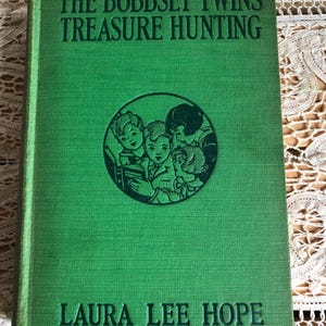 A Hardback Book Titled The Bobbsey Twins Treasure Hunting By Laura Lee Hope Copyright 1929 By Grosset & Dunlap, Inc See Description