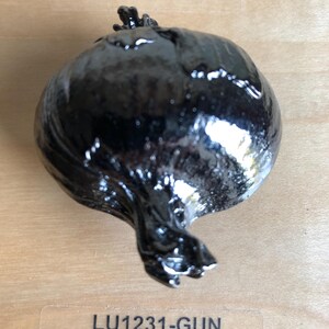 May include: A dark, glossy, onion-shaped ceramic sculpture with a textured surface. The sculpture is a warm pewter color and sits on a light wood surface. The text "LU1226-WPE Warm Pewter" is visible.