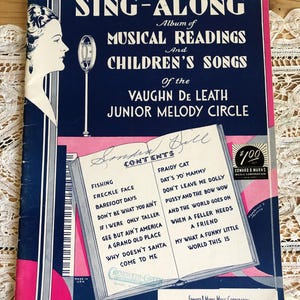 May include: Vintage "Sing-Along" songbook featuring "Musical Readings and Children's Songs" by Vaughn De Leath. The cover is navy blue and pink, with a woman's profile and a microphone illustration. The book includes a contents page with song titles.