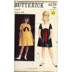 May include: Vintage Butterick sewing pattern featuring two dress designs. The pattern includes a yellow dress with a black bow and a black dress with a white collar and red ribbon. The pattern size is 6, with a 24-inch bust.