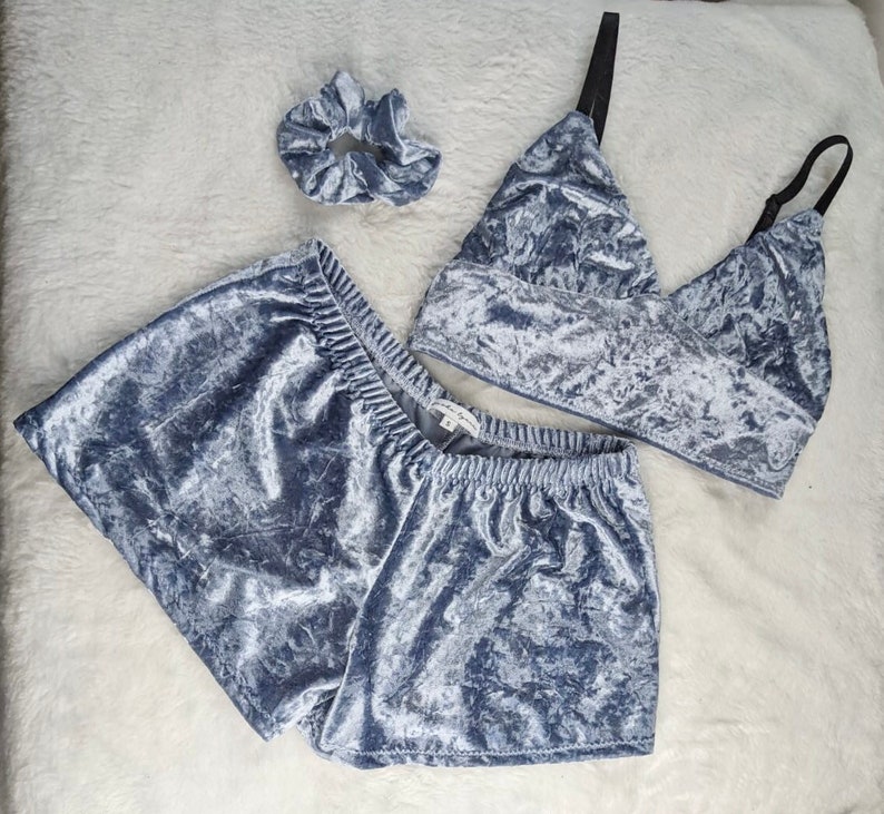 May include: A gray crushed velvet pajama set with a matching scrunchie. The set includes a cropped top with a V-neck and shorts.