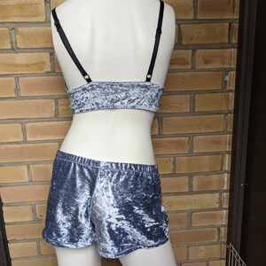 May include: A gray velvet crop top with black straps and matching shorts. The fabric has a crushed velvet texture.