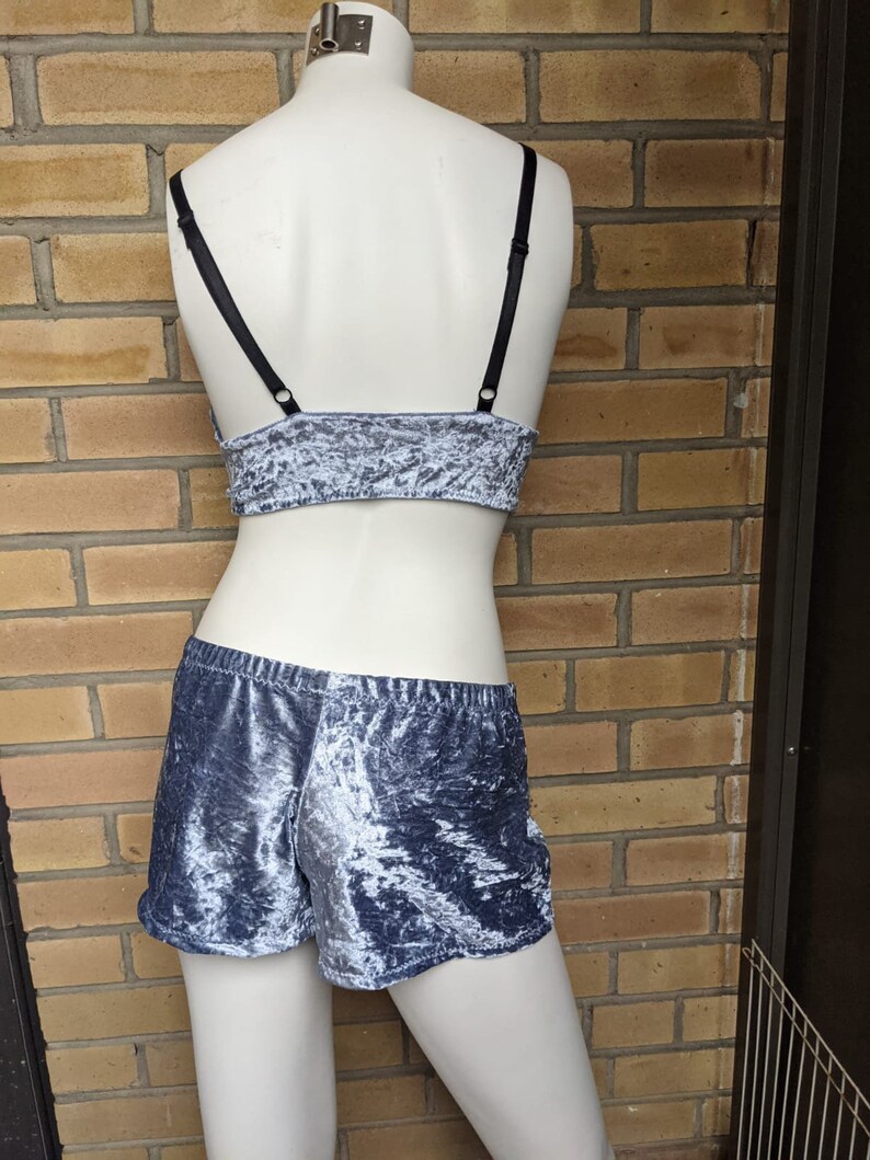 May include: A gray velvet crop top with black straps and matching shorts. The fabric has a crushed velvet texture.