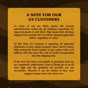 May include: A gold-toned rectangular graphic with the text "A NOTE FOR OUR US CUSTOMERS." The text explains changes to import duties for US customers, including prepaid duties and tariff costs.