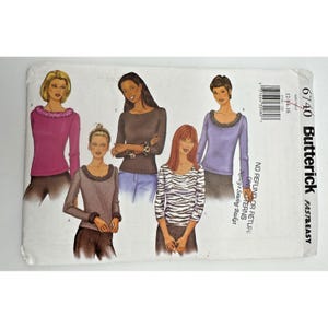 May include: Butterick sewing pattern 6740, featuring illustrations of long-sleeved tops with decorative necklines. The pattern includes sizes 12-14-16. The cover is white with the Butterick logo and text.