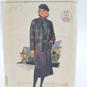 Könnte beinhalten: Ein Vintage-Nähmusterumschlag für eine karierte Jacke und einen Rock. Das Muster ist von Butterick und ist für Größe 14. Der Umschlag zeigt eine Zeichnung einer Frau, die das Outfit trägt und vor einem Gebäude steht. Der Text auf dem Umschlag lautet "Butterick", "6870", "Pattern/Patron", "14", "J.G. Hook", "No Refunds Exchanges on Patterns Yardage Fair, Inc."