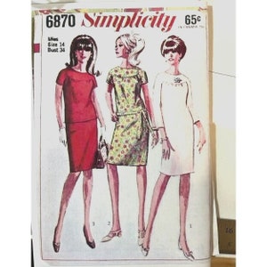 May include: Vintage Simplicity sewing pattern number 6870 for a dress. The pattern is for misses sizes 14 with a bust of 34 inches. The pattern shows three different styles of dresses, one red, one green with a floral print, and one white.