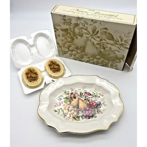 Puede incluir: Un juego vintage de Avon Nature Bountiful con dos jabones ovales, un plato decorativo de cerámica y una caja. Los jabones y el plato están decorados con motivos de frutas y pájaros. El plato tiene un borde dorado.