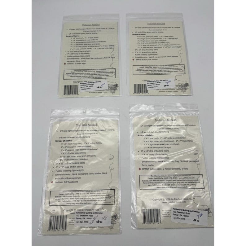 Op de afbeelding: Vier doorzichtige plastic zakken met quiltmaterialen en instructies. Elke zak heeft een witte papieren inlegger met een lijst van benodigde materialen voor een quiltproject. De zakken zijn gerangschikt op een wit oppervlak.