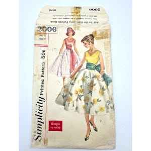 May include: Vintage Simplicity pattern envelope, featuring illustrations of dresses. The envelope is marked "2006" and "Size 12, Bust 37". The design includes a yellow and white floral dress and a pink dress. The text reads "Ask for the Simplicity Pattern Book".