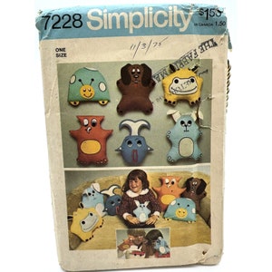 May include: Vintage Simplicity sewing pattern 7228 featuring various stuffed animal designs. The pattern cover shows a variety of colorful, whimsical creatures, including a turtle, dog, and bunny. The cover also shows a child wearing a sweater with a bunny design.