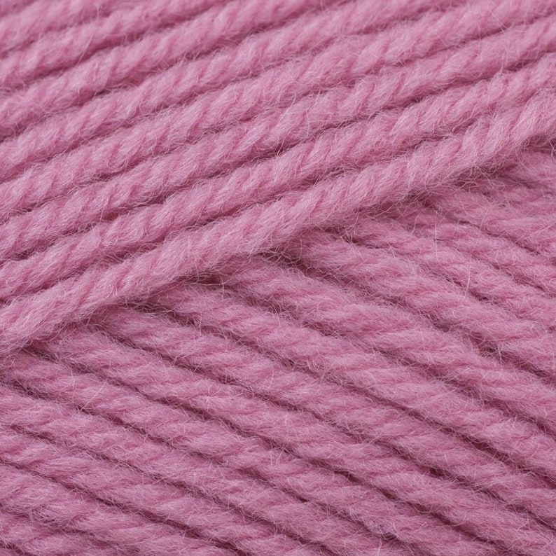 May include: Close-up of a soft, pink yarn. The yarn is made of wool and has a fuzzy texture.