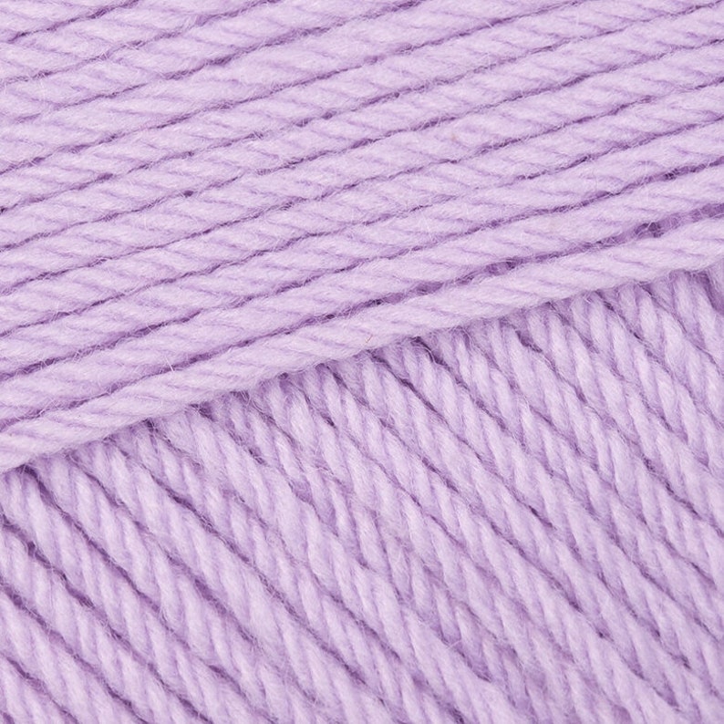 May include: Close-up of a soft, lavender-colored yarn. The yarn is made of a single strand and has a slightly textured surface.
