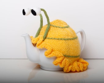 Knitted yellow snail tea cosy with frilly bottom. 6 cup and 2 cup sizes. Washable.