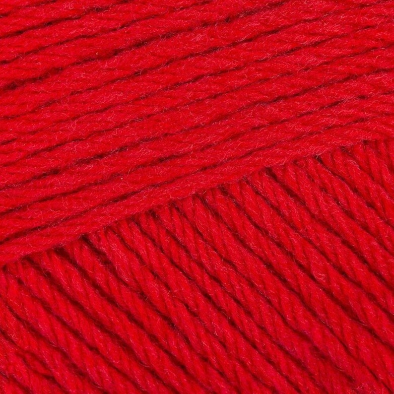 May include: Close-up of a red yarn with a textured surface. The yarn is made of soft fibers and has a slightly fuzzy appearance.