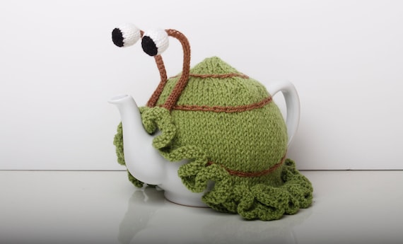 Knitted green snail tea cosy with frilly bottom. Washable fits 1 litre teapot.