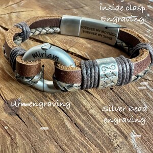 A personalized bracelet with engraved text and metal components, resting on a wooden surface.