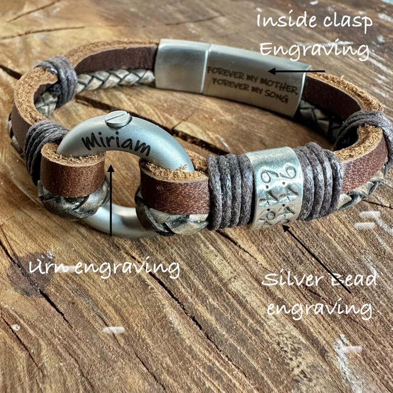 A personalized bracelet with engraved text and metal components, resting on a wooden surface.