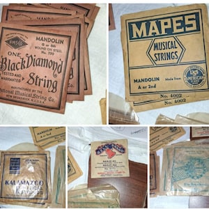 May include: A collection of vintage paper envelopes for musical instrument strings, including brands like Black Diamond, Mapes, Kalamazoo, and Bell Brand. The tan and brown paper packets feature black and blue printed text, logos, and string specifications.