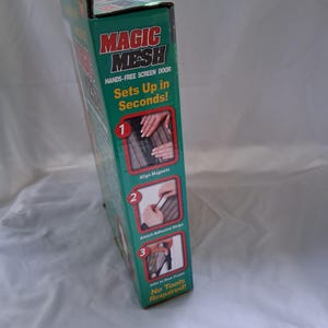 K&ouml;nnte beinhalten: Ein rechteckiger Produktkarton f&uuml;r eine freih&auml;ndige Magic Mesh-Fliegengittert&uuml;r. Die gr&uuml;ne Verpackung zeigt den Produktnamen in roter und wei&szlig;er Schrift sowie drei nummerierte Anleitungsbilder, die zeigen, wie man Magnete ausrichtet, Klebestreifen anbringt und das Gitter ohne Werkzeug am T&uuml;rrahmen befestigt.