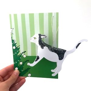 Carte de Noël avec ornement arbre à chat, petit cadeau chat blanc et noir.