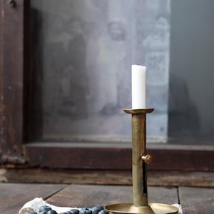 Candelabro antiguo de latón con mecanismo de empuje: portavelas rústico para velas cónicas con pomo lateral decorativo, pátina y mecanismo de elevación que no funciona.