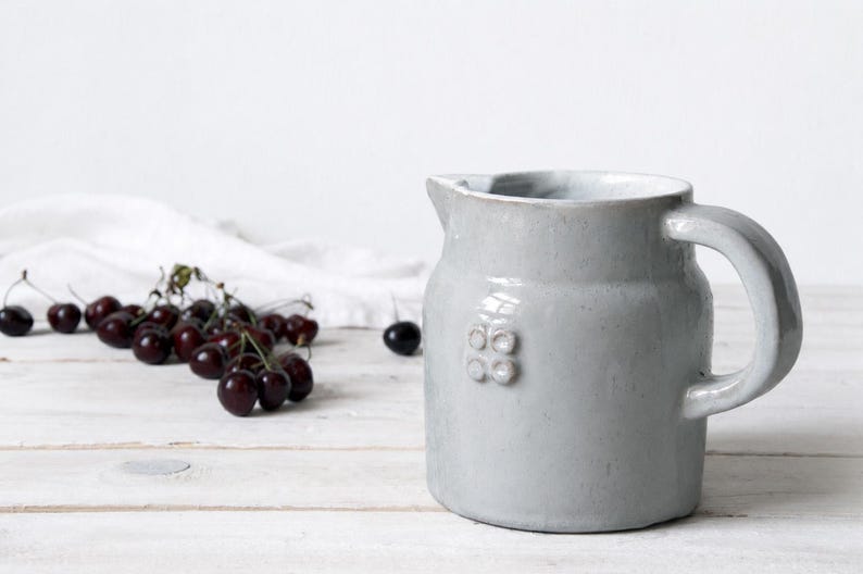Vintage farmhouse stoneware jug with pale ceramic glaze and rustic handmade pottery character