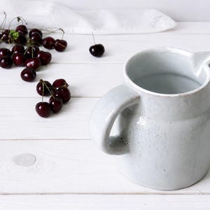 Vintage stoneware jug vase with pale speckled glaze and curved handle