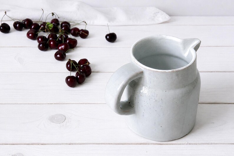 Vintage stoneware jug vase with pale speckled glaze and curved handle