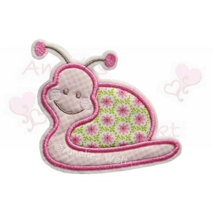 Könnte beinhalten: Ein gesticktes Schnecken-Applikation in Rosa und Weiß. Der Körper der Schnecke hat ein hellrosa Vichy-Muster, und das Gehäuse weist ein Blumenmuster mit rosa Blüten und grünen Blättern auf. Die Applikation hat ein lächelndes Gesicht und ist rosa umrandet.