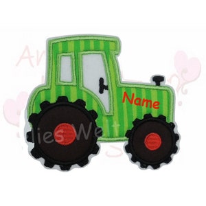 Könnte beinhalten: Ein grün-weißes Traktor-Applikation mit schwarzen Rädern und einem roten Mittelpunkt. Der Traktor hat ein weißes Fenster und das Wort "Name" in Rot. Die Applikation ist mit einem Streifenmuster versehen.
