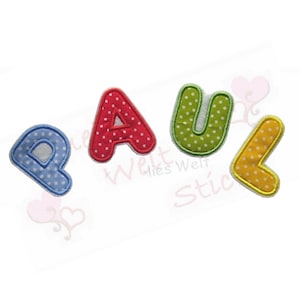 Könnte beinhalten: Vier Stoffbuchstaben mit der Aufschrift "PAUL". Die Buchstaben sind blau, rot, grün und gelb mit weißen Punkten. Die Buchstaben haben einen weißen Rand und befinden sich auf weißem Hintergrund.