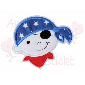 Könnte beinhalten: Gestickter Aufnäher mit einem Cartoon-Piraten-Gesicht. Der Pirat hat ein blaues Bandana mit weißen Sternen, eine schwarze Augenklappe und ein rotes Halstuch. Das Gesicht ist weiß mit einem lächelnden Ausdruck.