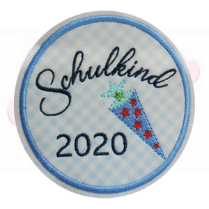 Könnte beinhalten: Ein runder Aufnäher mit blauem Rand und hellblau-weißem Vichy-Hintergrund. Der Aufnäher zeigt das Wort "Schulkind" in dunkelblauer Schrift, ein blau-rotes kegelförmiges Design und die Zahl "2020" in Dunkelblau.