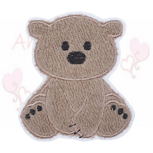 Könnte beinhalten: Ein brauner Teddybär-Aufnäher mit weißem Rand. Der Bär hat schwarze Augen und Nase sowie schwarze Pfoten. Der Aufnäher ist mit einem strukturierten, plüschigen Aussehen und gestickten Details versehen.