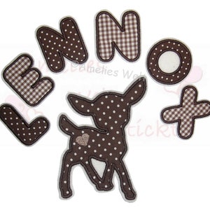 Könnte beinhalten: Eine Sammlung brauner Stoffaufnäher, darunter Buchstaben, eine Hirschsilhouette und ein Pluszeichen. Die Buchstaben haben ein Muster aus Punkten und Vichy-Karo. Der Hirsch hat ein Herzdetail.