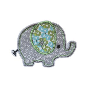 Könnte beinhalten: Graue, elefantenförmige Applikation mit Muster. Der Elefant hat einen grauen Körper mit weißen Kreisen, ein grün-blau gemustertes Ohr und einen Sternakzent. Die Applikation ist grün umrandet und hat ein schwarzes Auge.