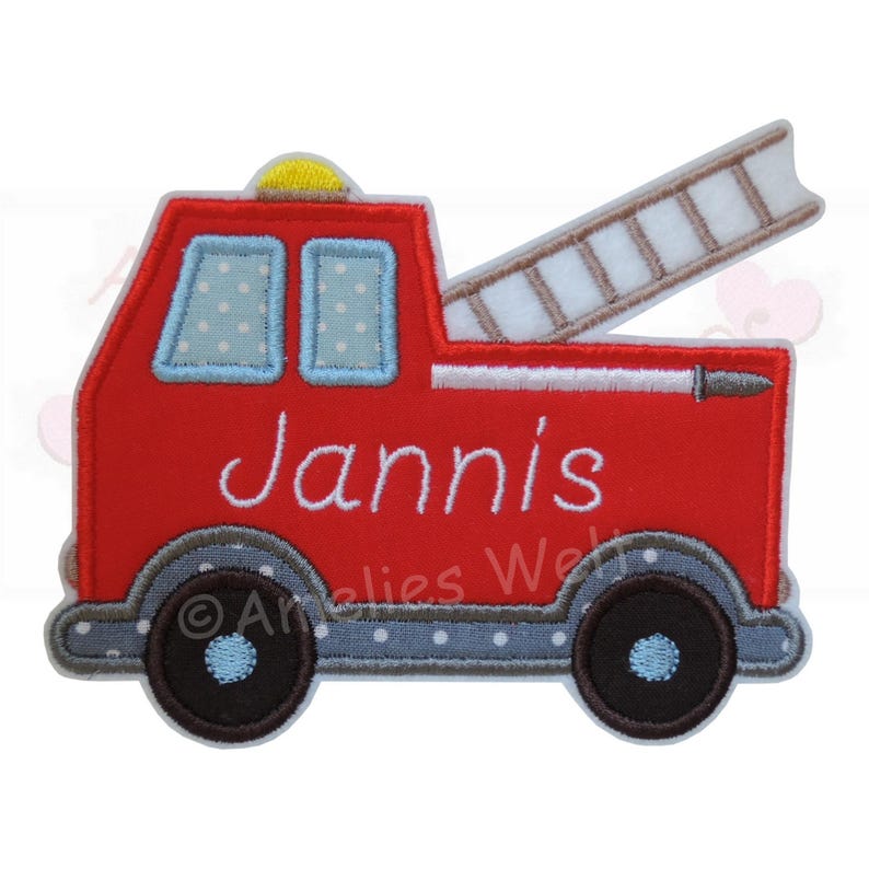 May include: A red fire truck applique with the name "Jannis" embroidered in white. The truck features a ladder, two windows with blue polka dots, and black wheels. A yellow light is on top.