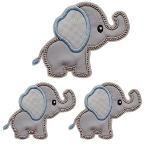 Könnte beinhalten: Drei graue Elefanten-Applikationen mit blauen Akzenten. Jede Applikation hat ein hellblaues Ohr mit Vichy-Muster und blauem Umriss. Die Applikationen sind mit einem genähten Rand und einem kleinen Schwanz versehen.