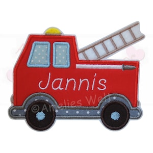 May include: A red fire truck applique with the name "Jannis" embroidered in white. The truck features a ladder, two windows with blue polka dots, and black wheels. A yellow light is on top.