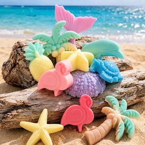 May include: A collection of small, molded tropical-themed items in pastel colors, including a pink flamingo, yellow pineapple, light green palm tree, blue turtle, light blue dolphin, purple sea urchin, and yellow starfish, arranged on a piece of driftwood.