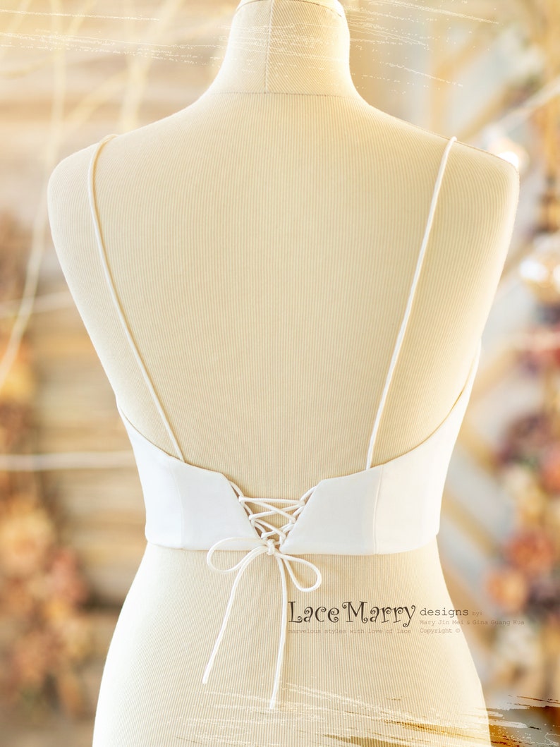 Pu&ograve; includere: Corsetto da sposa in satin bianco con lacci sul retro. Il corsetto ha una scollatura a cuore e spalline regolabili. La parte posteriore del corsetto &egrave; legata con un nastro di raso.