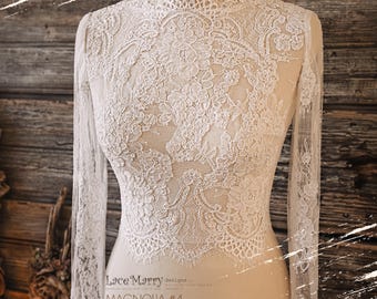 May include: White lace bridal bolero with long sleeves. The lace has a floral pattern. The bolero is on a dress form. The text "Lace'Marry designs" and "MAGNOLIA #4" is on the dress form.