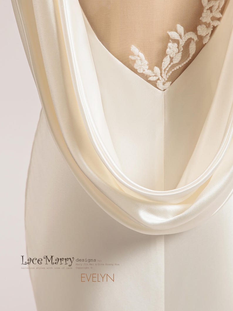 Pu&ograve; includere: Un abito da sposa in satin bianco con schiena scoperta e un delicato ricamo in pizzo. L'abito ha un design fluido e drappeggiato e una silhouette semplice ed elegante. Il testo "Lace Marry designs by Mary Jin Wei & Tina Guang Hua Copyright &copy;" &egrave; stampato sull'abito.